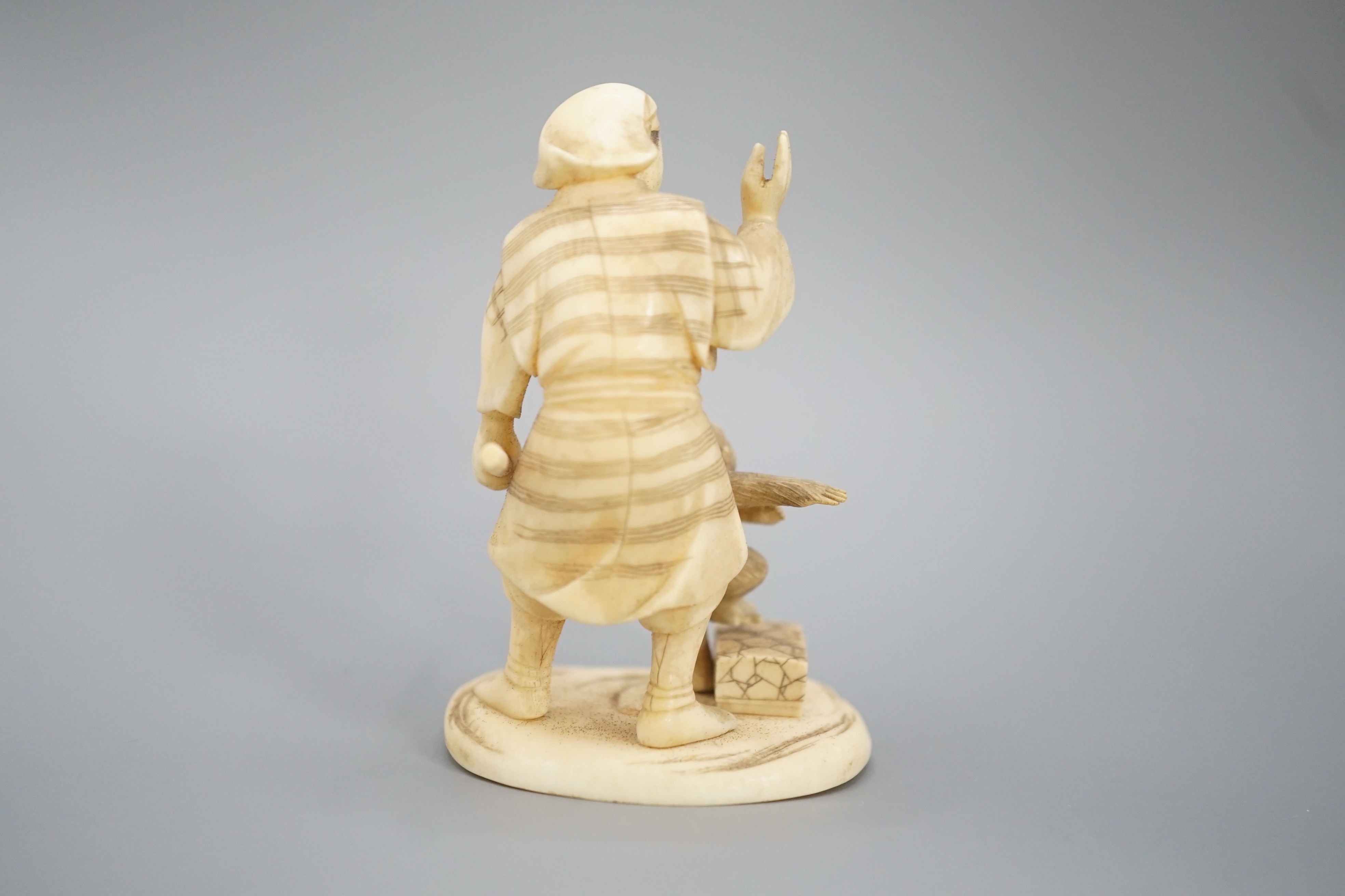 A Japanese ivory okimono of a monkey trainer, signed, Meiji period, 7.7 cm
